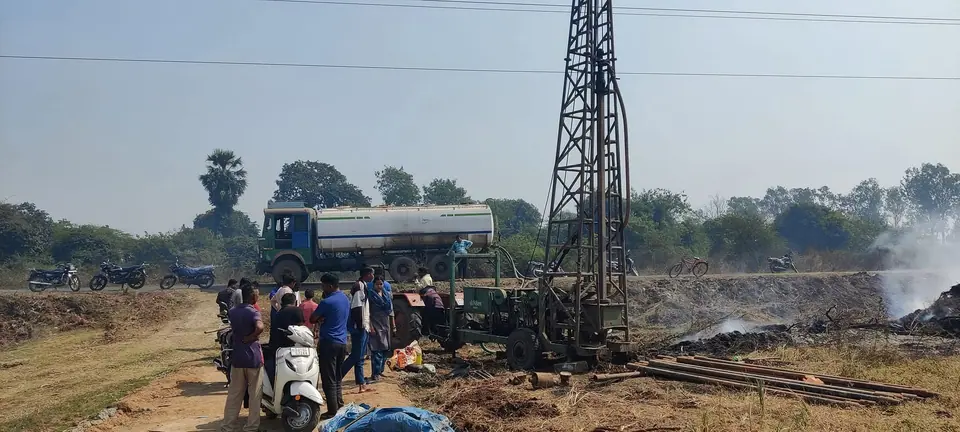 Borewell drilling rig in field