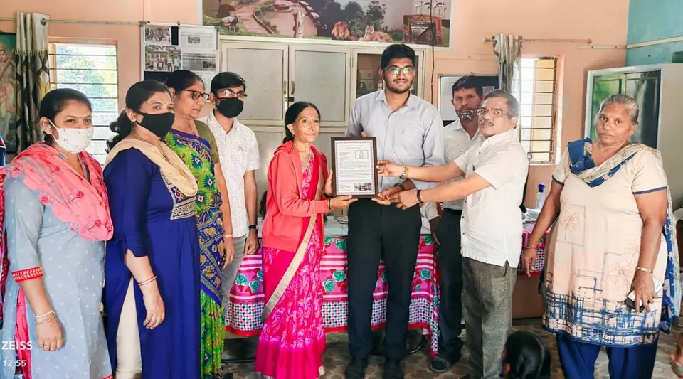 Certificate/frame handover in office, women staff