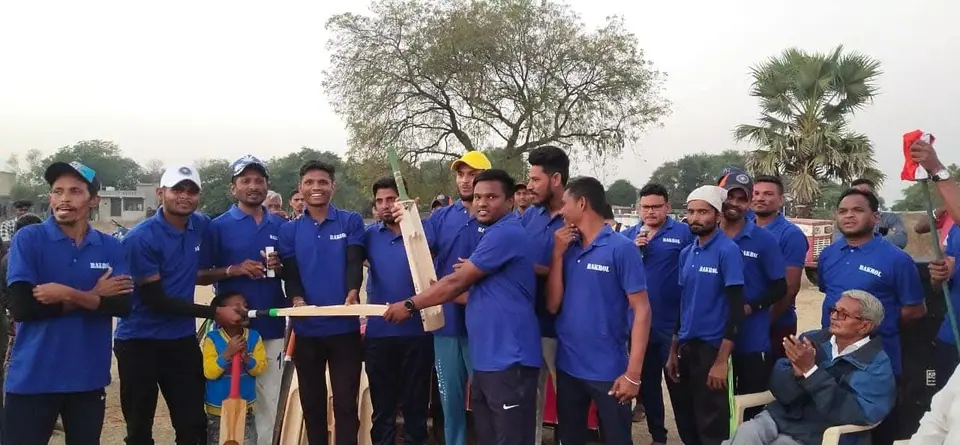 Cricket team in blue jerseys, trophy