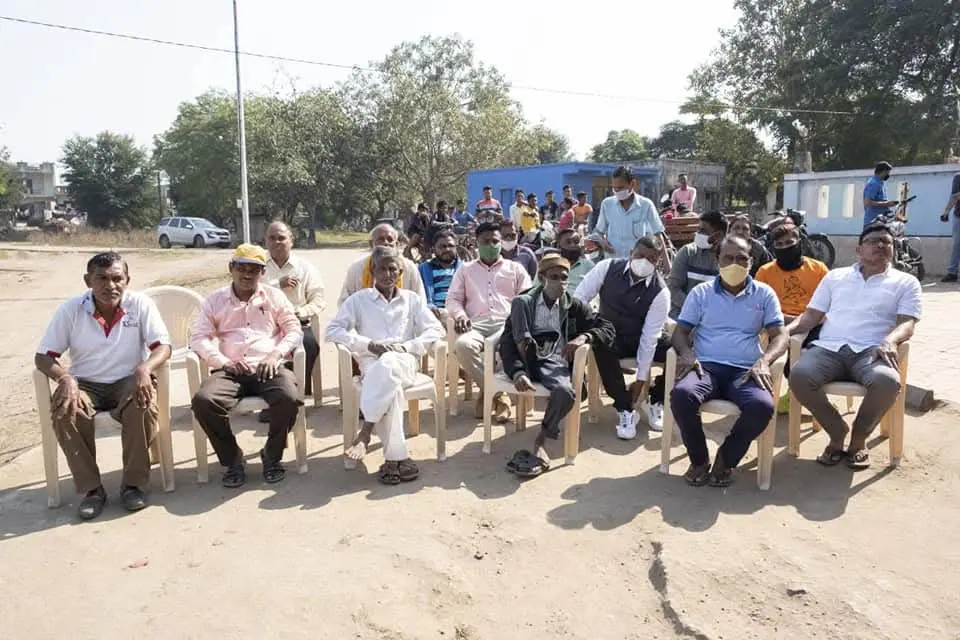 Elders seated in plastic chairs outdoors