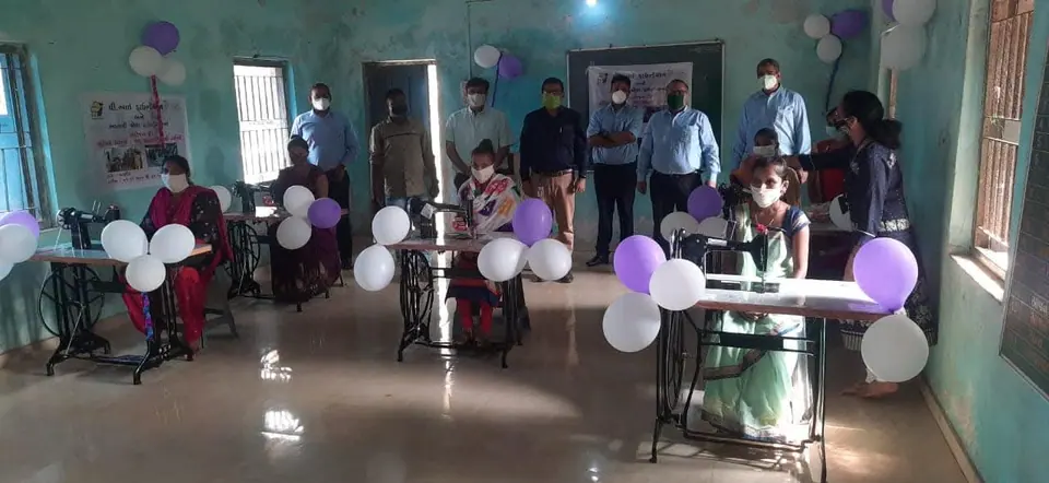Sewing machine training centre room with balloons, officials