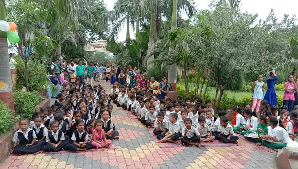 Schoolchildren seated in garden
