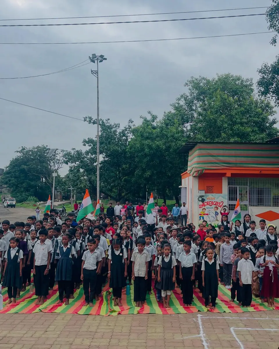 School assembly with tricolour flags, children in uniform