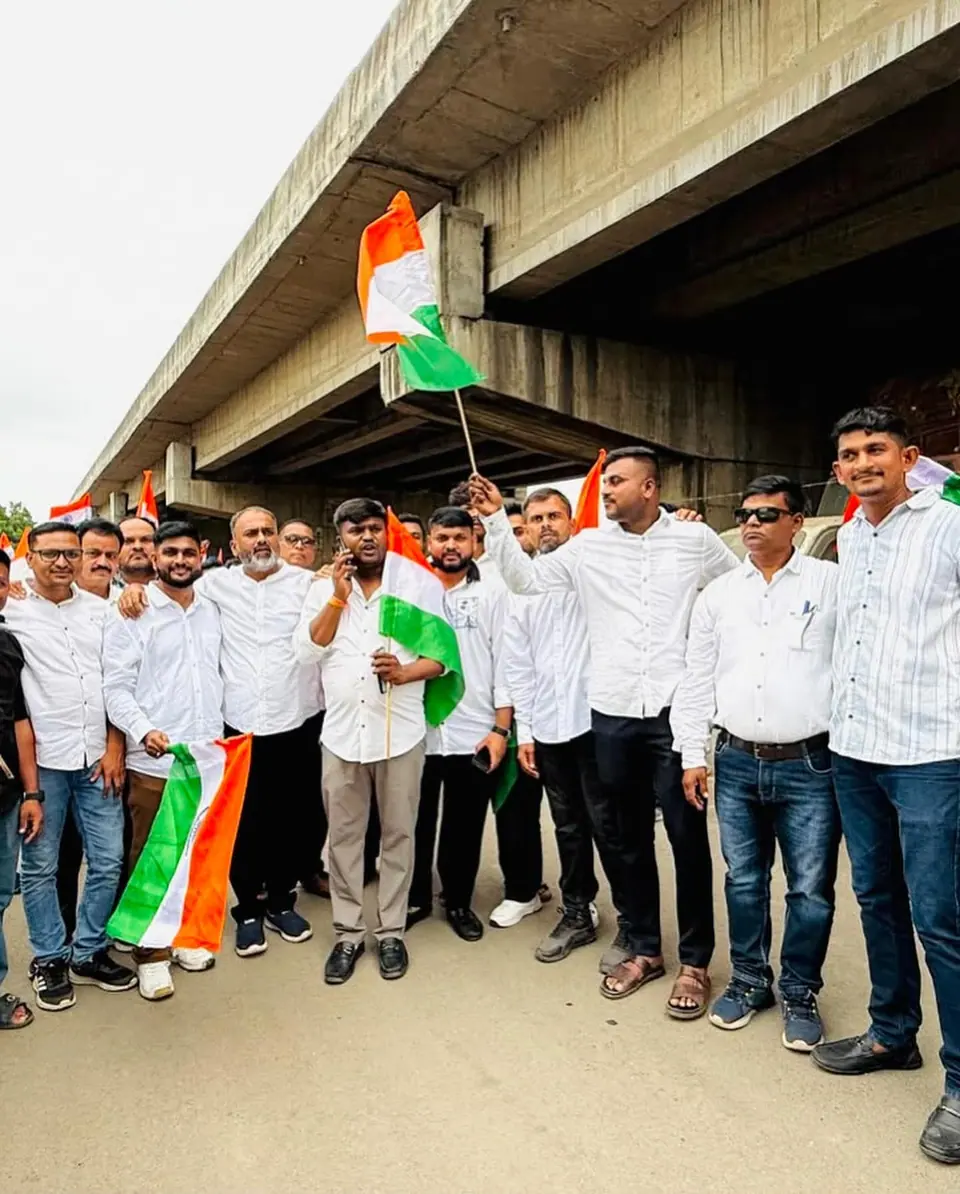 Group with tricolour flags under a flyover