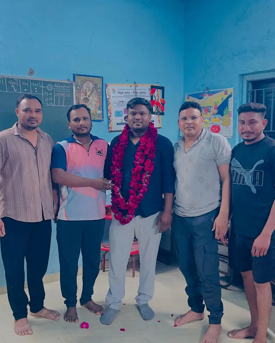 Man garlanded in classroom with group