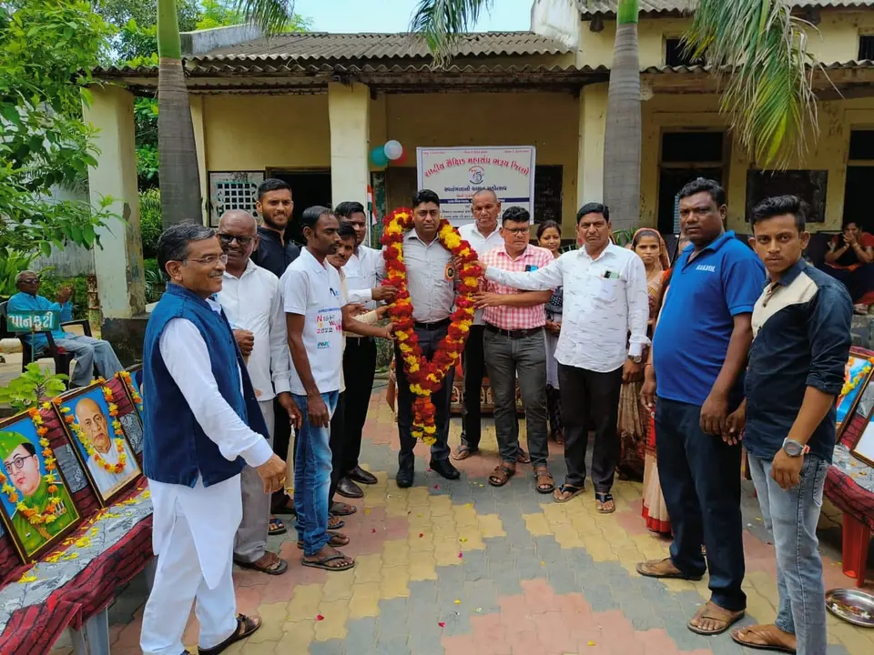 Garlanded man with group at school